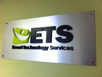 Brushed silver panel with 3D lettering installed on the wall with standoffs